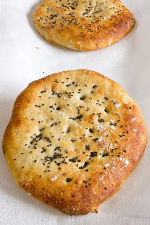 two pieces of bread with black pepper sprinkled on them sitting on a white surface