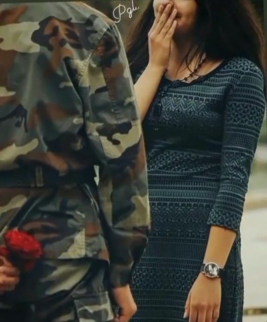 a man and woman standing next to each other in front of a soldier's uniform