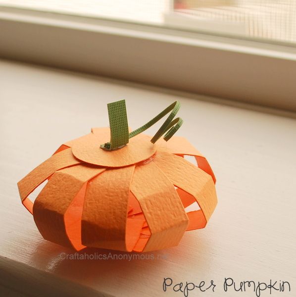 an orange paper pumpkin sitting on top of a window sill