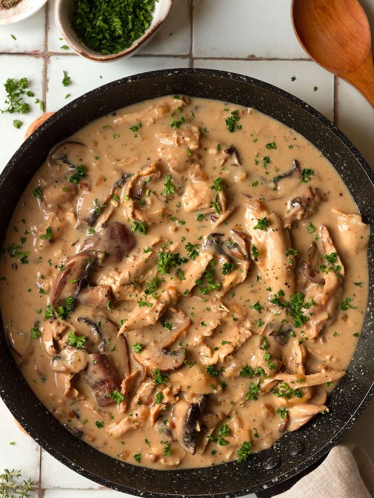 a skillet filled with mushroom gravy on top of a table