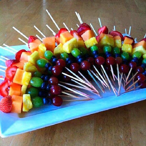 a platter filled with fruit and skewers