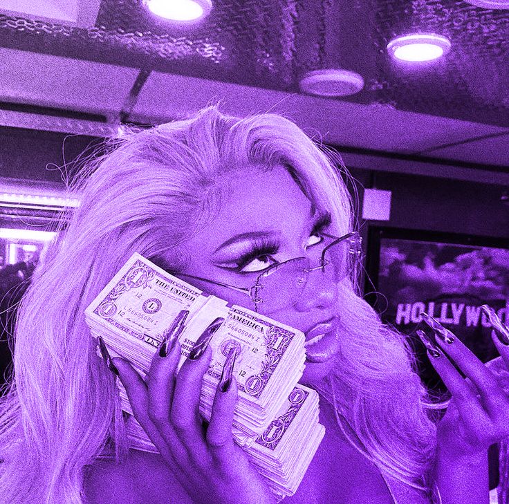 a woman with glasses and money in her mouth is talking on the phone while wearing purple makeup