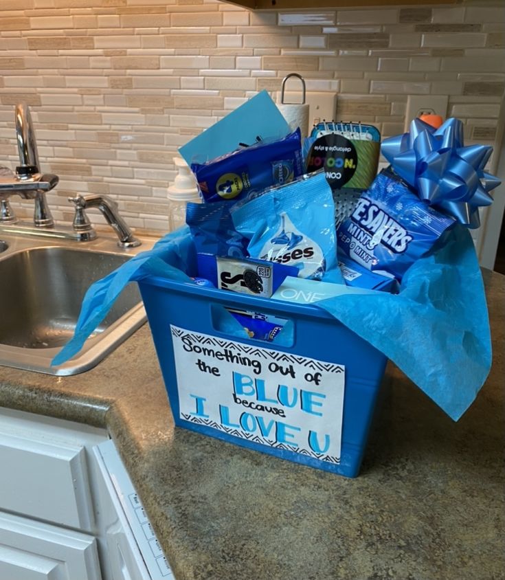 a blue basket filled with items on top of a kitchen counter