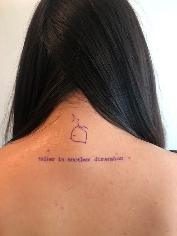 the back of a woman's neck with a tattoo that reads, talent in another dimension