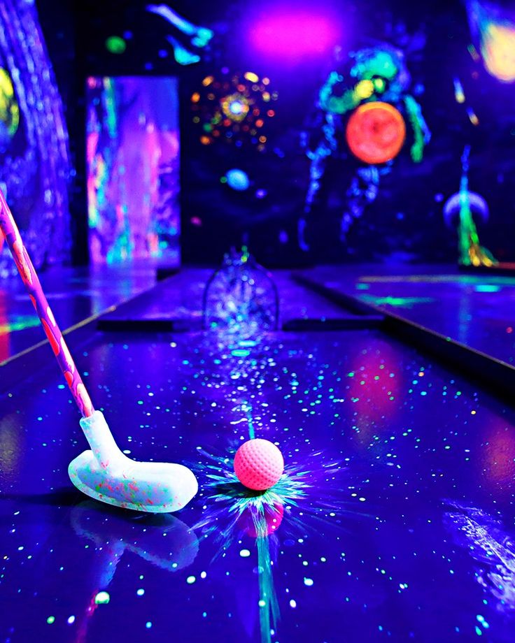 a golf ball and tee on a bowling table