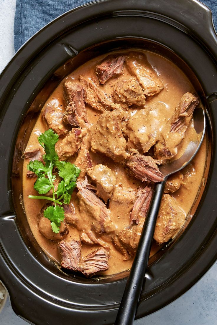 a close up of a bowl of food with meat and gravy on it