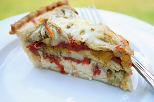 a slice of lasagna pie on a white plate with a fork in the foreground