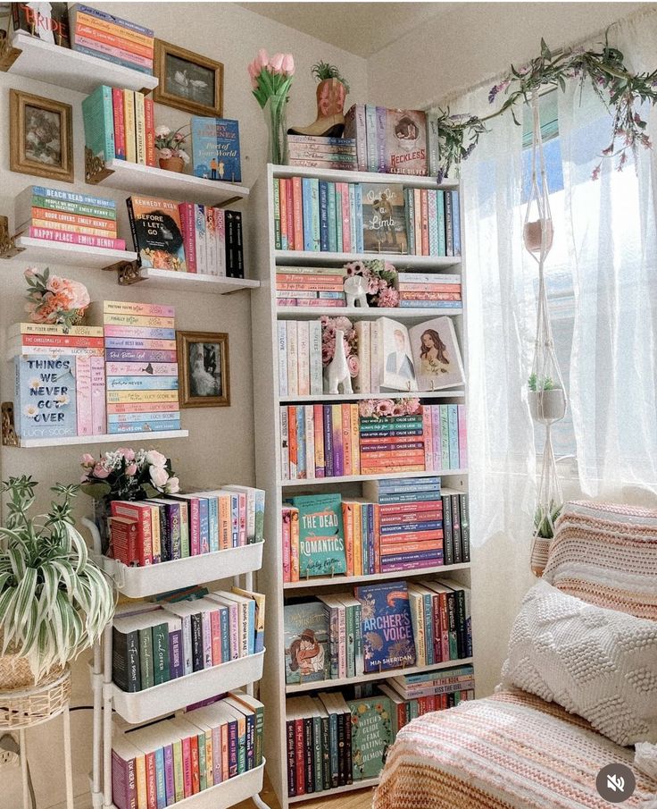 a room filled with lots of books on top of a book shelf next to a window