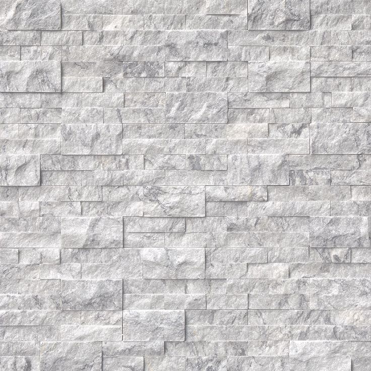 a white brick wall that is made out of marble blocks and has grey veining on it