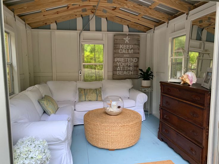 a living room filled with white furniture and lots of wooden beams on the ceiling,