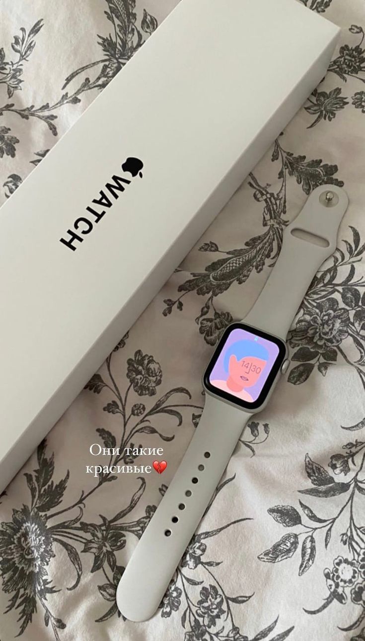 an apple watch sitting on top of a bed next to a box