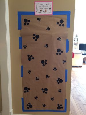 a door decorated with dog paw prints and blue tape on the bottom half of it