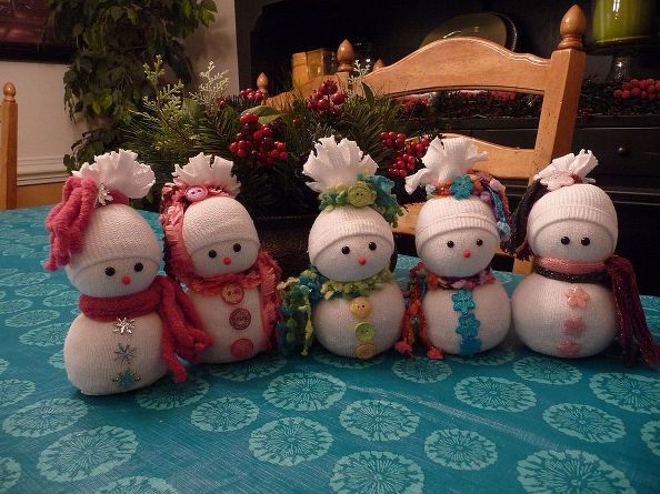 four snowmen sitting on top of a blue table cloth