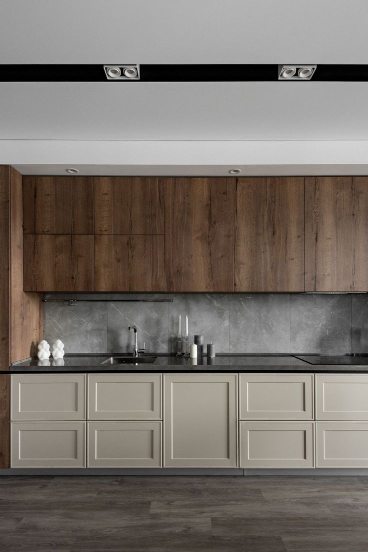 an empty kitchen with wooden cabinets and black counter tops on the wall, along with white vases