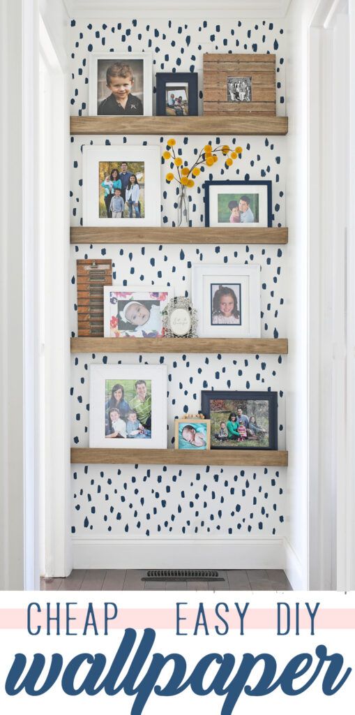 an easy diy wallpaper project with pictures and frames on the shelves in front of it