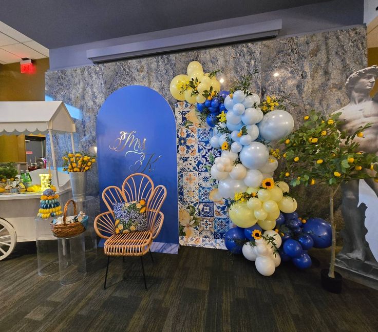 a room with balloons and decorations on the wall, including a blue door in the center