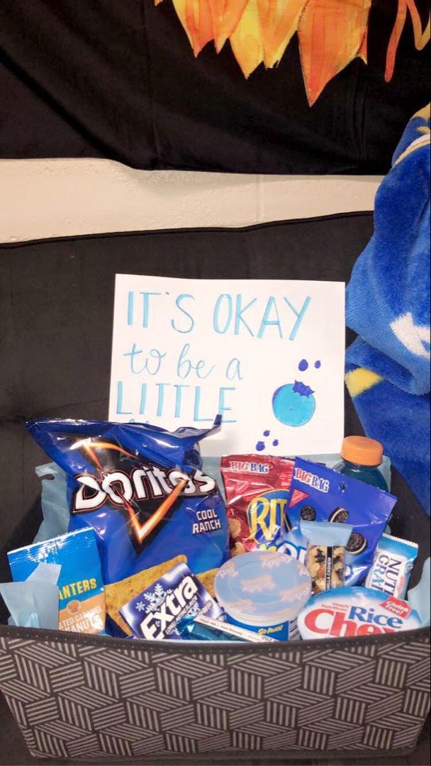 a basket filled with snacks and candy next to a sign that says it's okay to be a little