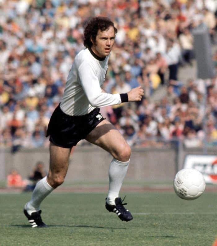 a man is playing soccer in front of a large crowd at a sporting event on the field