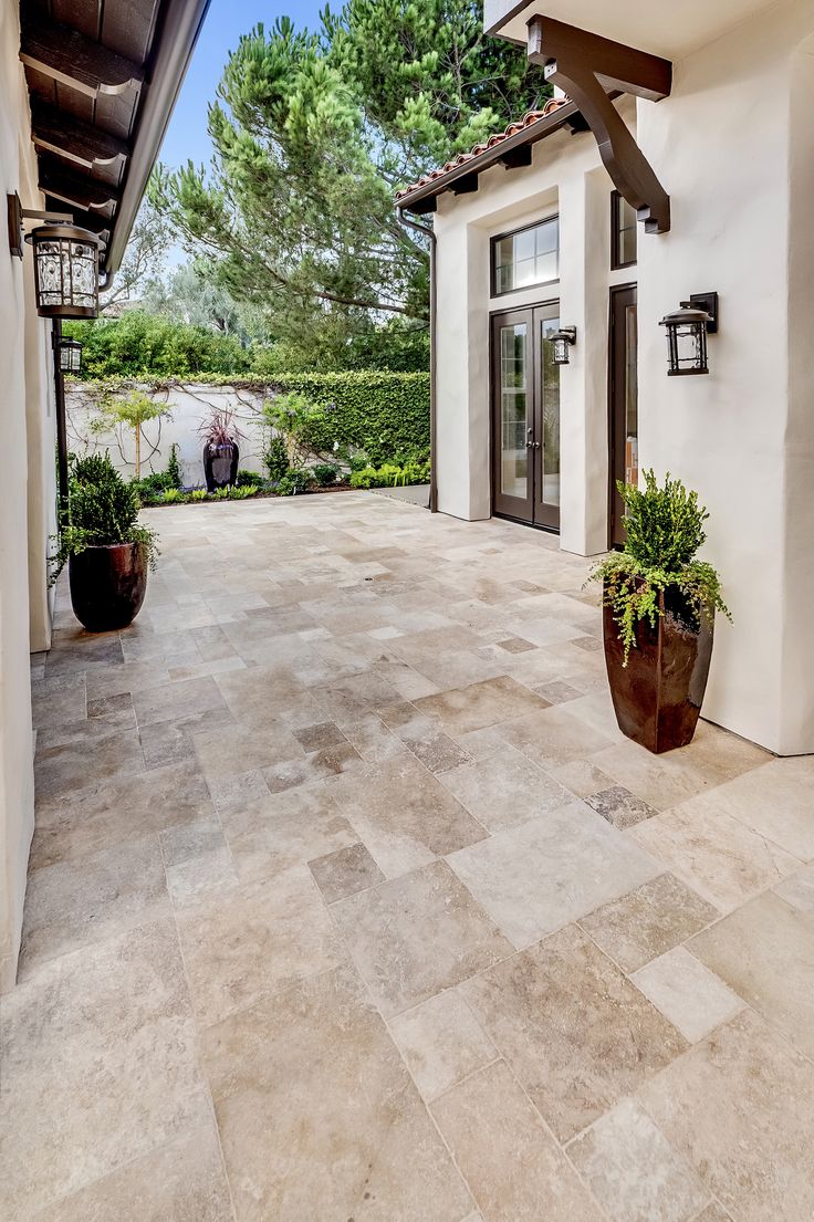 an outdoor patio with potted plants on the side