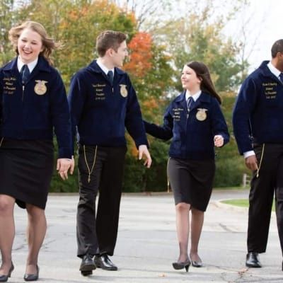 a group of people in uniform walking down the street with their hands in each other's pockets