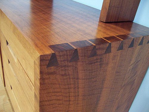 a close up of a wooden dresser with an arrow pattern on the top and bottom