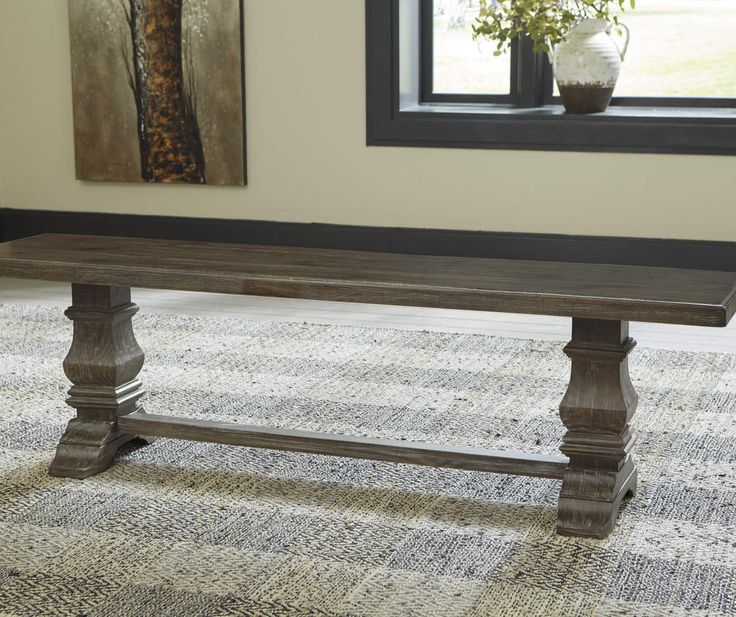 a wooden table sitting in front of a window on top of a carpeted floor