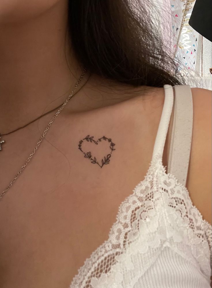 a woman with a heart tattoo on her chest