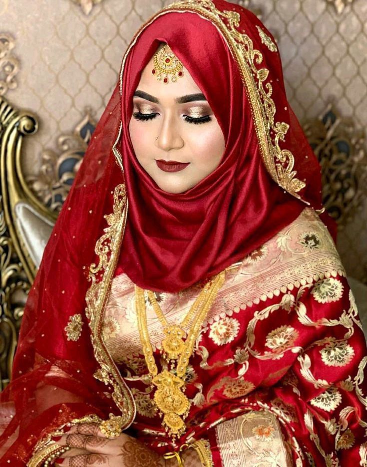 a woman in a red and gold outfit sitting on a chair with her eyes closed