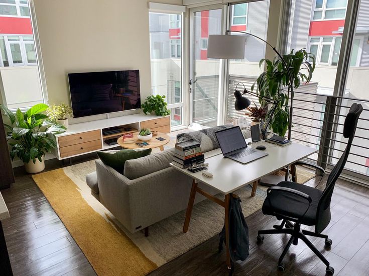 a living room filled with furniture and a flat screen tv on top of a wooden table