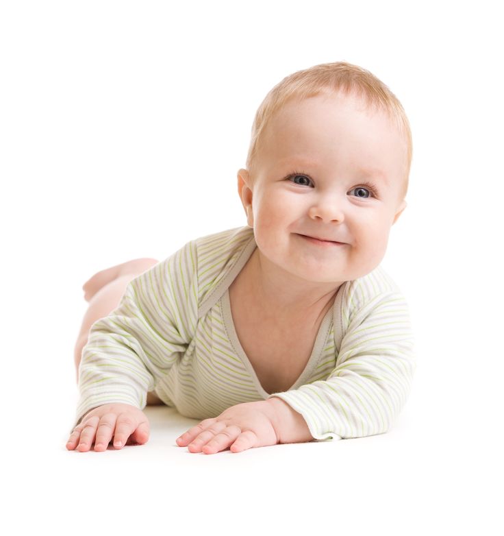 a baby laying on the floor smiling at the camera