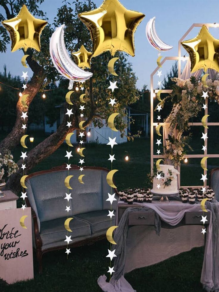 an outdoor setting with stars and moon balloons