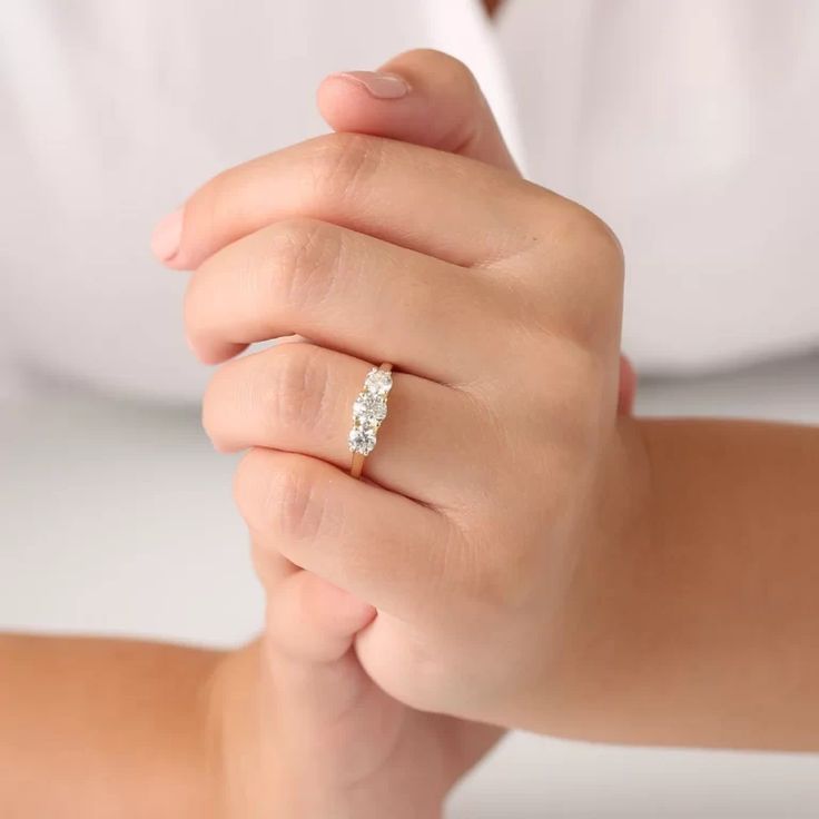 a woman's hand with a diamond ring on it