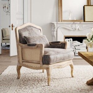 a chair sitting on top of a rug in front of a table with flowers next to it