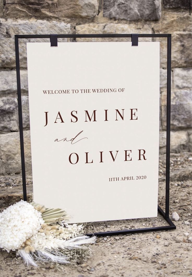 the welcome sign is next to a bouquet of white flowers and feathers on the ground