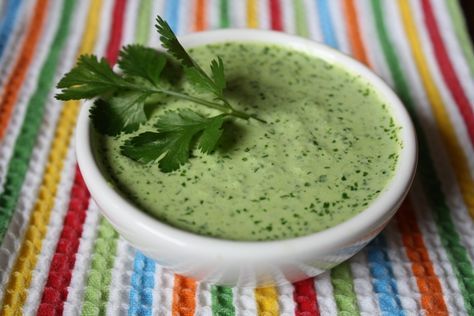 a white bowl filled with broccoli soup on top of a colorful table cloth