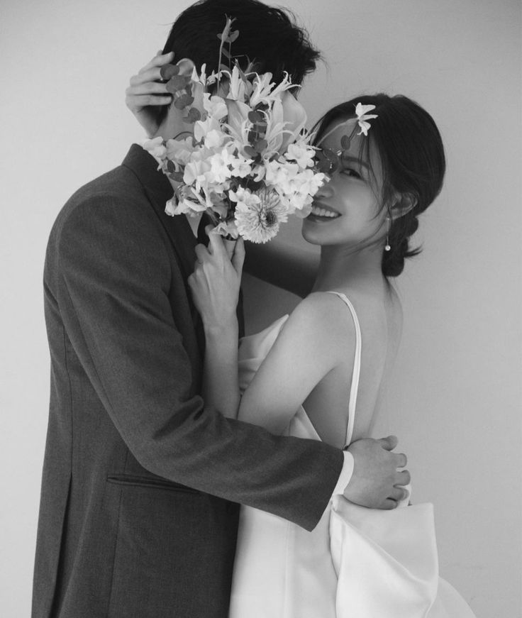 a bride and groom embracing each other in black and white