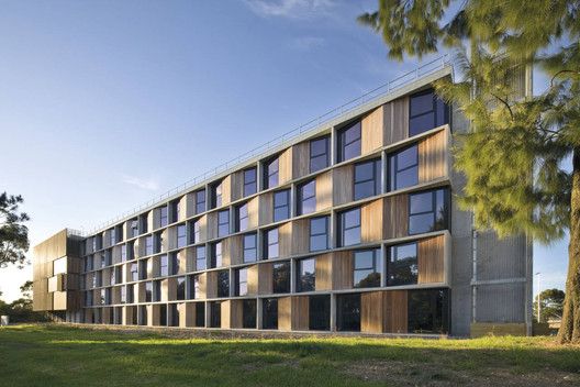 a large building with lots of windows on the side of it and grass in front of it