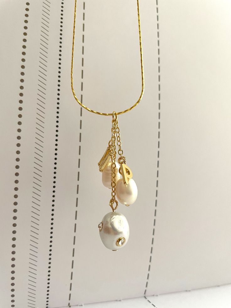 Our Generation Necklace was inspired on creating a meaninful keepsake for moms. The zirconia pearl symbolize the MOM and the smaller pearls symbolize the children. Each pearl that represents the children have a their initial. To order your necklace choose the amount of children-pearls you want on your necklace and on the description box, insert the initials of the children. For any other requests, contact us through our email (vita.ambita@gmail.com) Minimalist White Necklace With Charms, Anniversary Pearl Charm Dangle Jewelry, Anniversary Dangle Jewelry With Pearl Charm, Dangle Jewelry With Pearl Charm For Anniversary, Everyday Pearl Charm Necklace With Pearl Chain, Everyday Pearl Chain Charm Necklace, Pearl White Jewelry With Pearl Charm For Jewelry Making, Mother's Day Pearl White Jewelry With Pearl Charm, Mother's Day Pearl Drop Jewelry