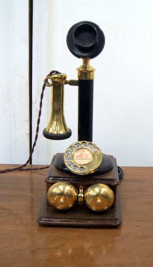 an old fashioned phone is sitting on a wooden table with two bells attached to it