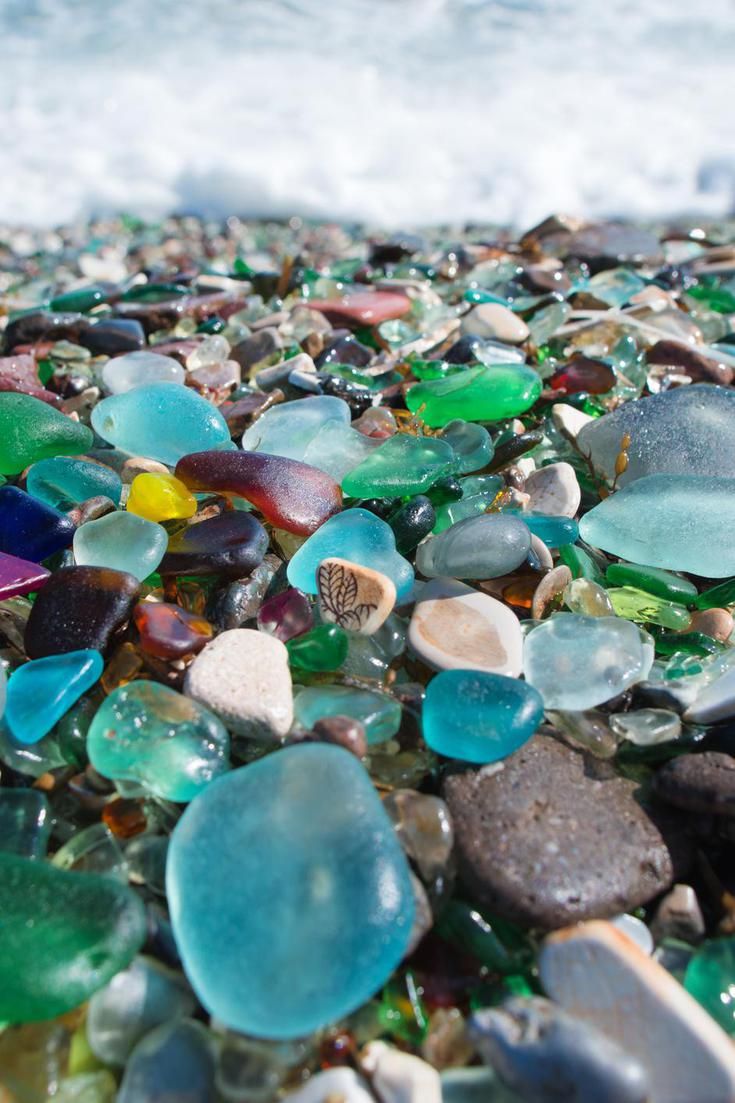 many different colored glass pebbles on the beach