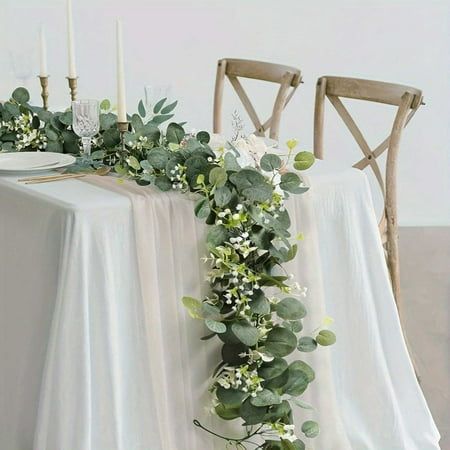 the table is decorated with greenery and candles