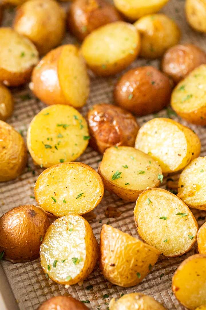 roasted potatoes with herbs on a baking sheet