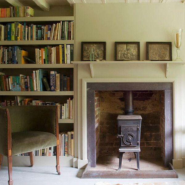 an old fashioned stove sitting in front of a bookshelf filled with lots of books