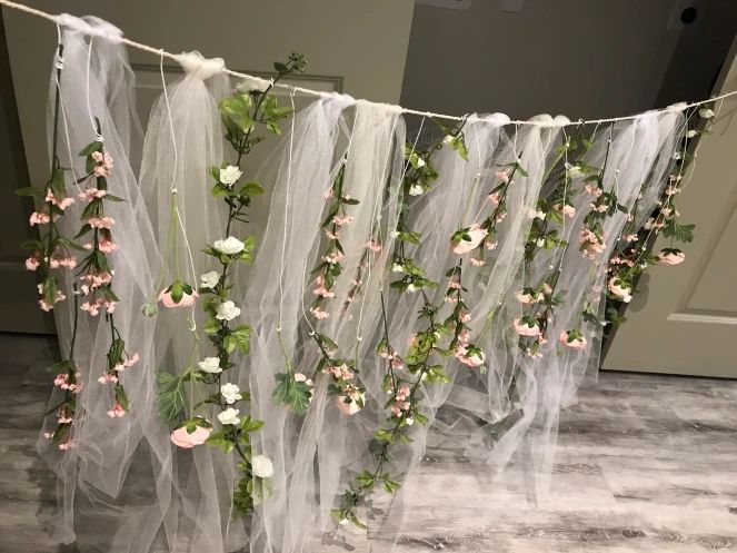 some flowers are hanging from a line on a string in front of a door with tulle