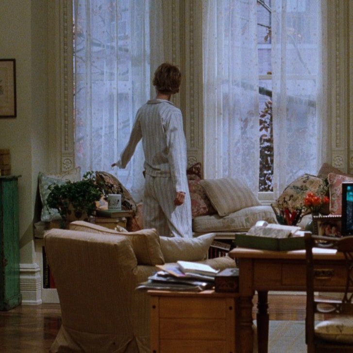 a woman standing in front of a living room window