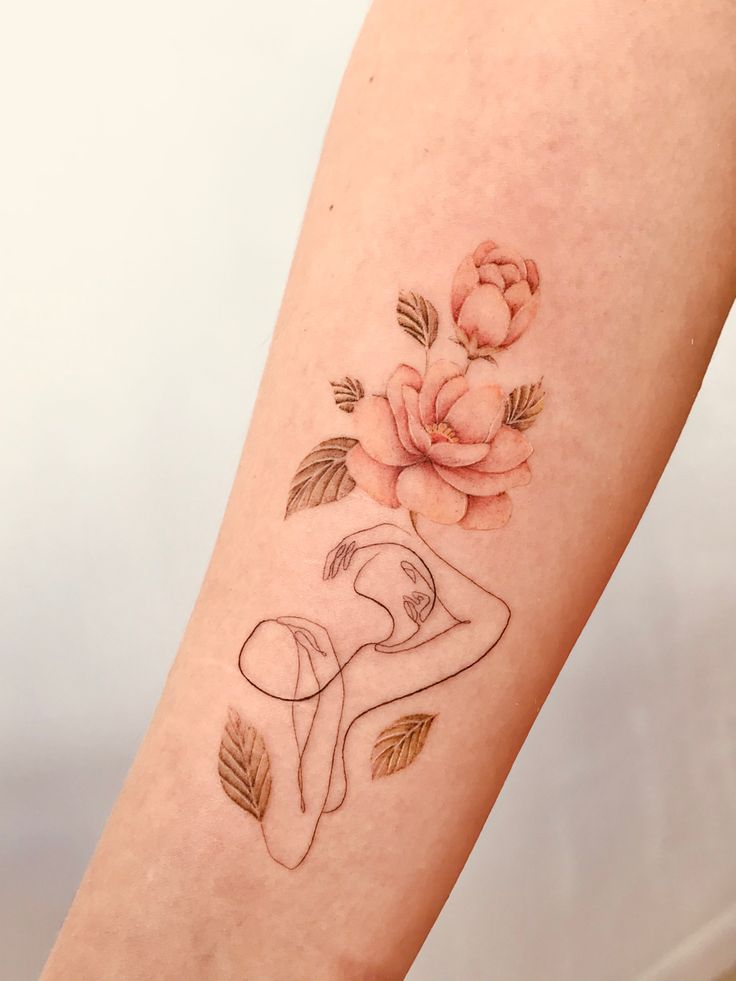 a woman's arm with a flower tattoo on it