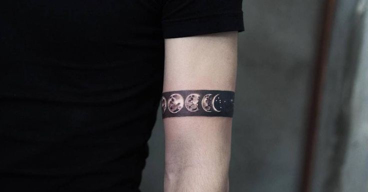 a man wearing a wrist tattoo with the phases of the moon on his left arm