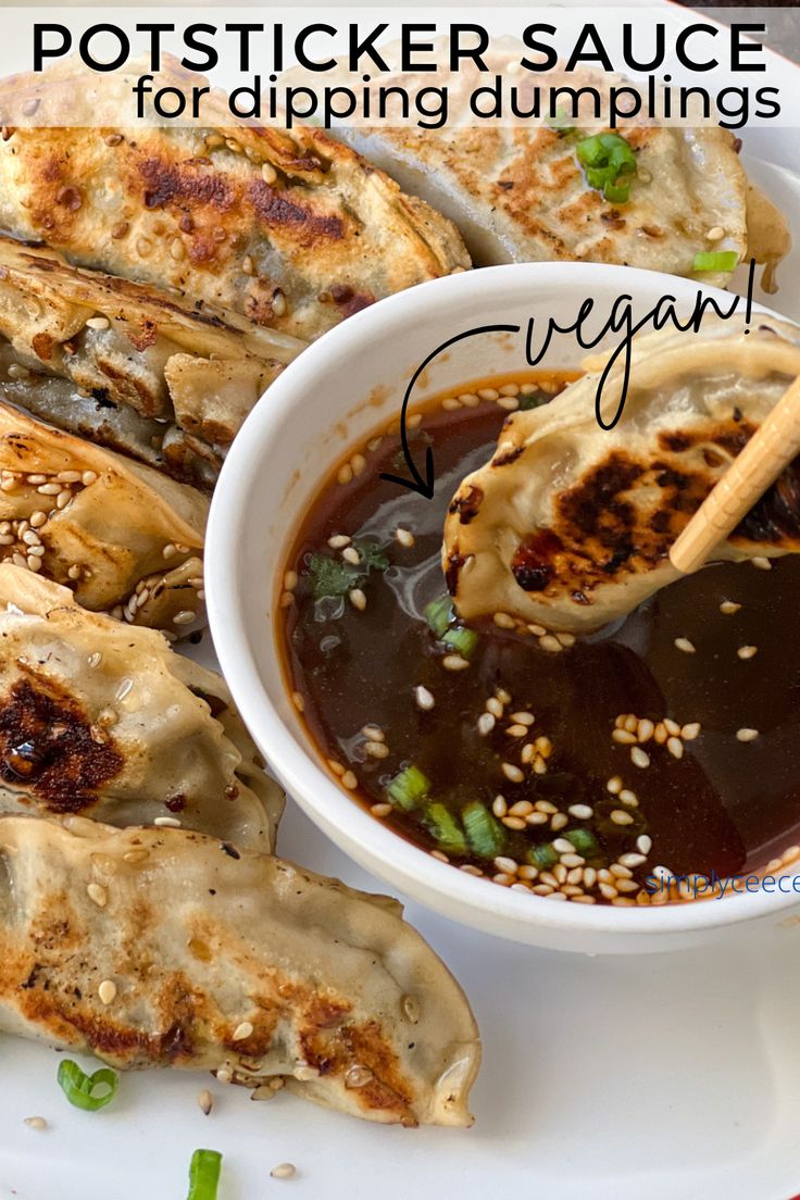 a white plate topped with dumplings next to a bowl of sauce and chopsticks