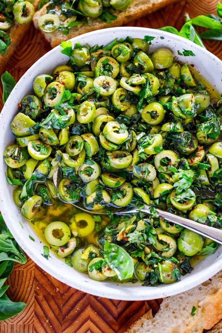 a white bowl filled with brussel sprouts and bread on top of a wooden table