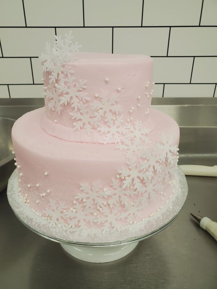 a pink frosted cake sitting on top of a table